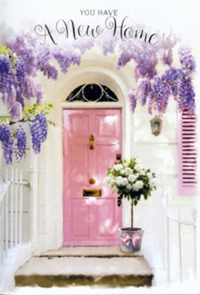 This doorway scene feels like a softly spoken promise of home in the heart of Alperton. The focus is a charming pink front door, painted in a delicate pastel shade that bridges blush and rose, its panels catching light in subtle highlights and shadows. Around it, wisteria pours down in generous lavender clusters, forming a loose, fragrant archway that recalls mature vines in hidden gardens near One Tree Hill Recreation Ground. The petals create a feathery canopy overhead, so that the door appears almost sheltered by floral drapery. To one side, a matching pastel shutter is propped half-open, its faded paint and lightly brushed edges hinting at years of sunshine and gentle breezes. The walls themselves are white and slightly textured, absorbing the warm daylight and reflecting it back with a soft, diffused glow. At ground level, placed carefully on the doorstep, a tin-style bucket stands full of white and creamy roses, some fully open and others still cupped around their centres. Fresh green foliage fills in the gaps, adding depth and contrast while keeping the palette serene. A soft pink ribbon encircles the base of the bucket, its loose tails resting against the step like a finishing touch to a lovingly wrapped present. The whole composition suggests a moment captured just before the door opens to greet guests or a new homeowner stepping over the threshold for the first time. It is easy to imagine this arrangement being delivered by a nearby florist in Alperton as a housewarming gift, a floral embrace that expresses optimism, gratitude, and the gentle excitement of starting again on a quiet residential street.